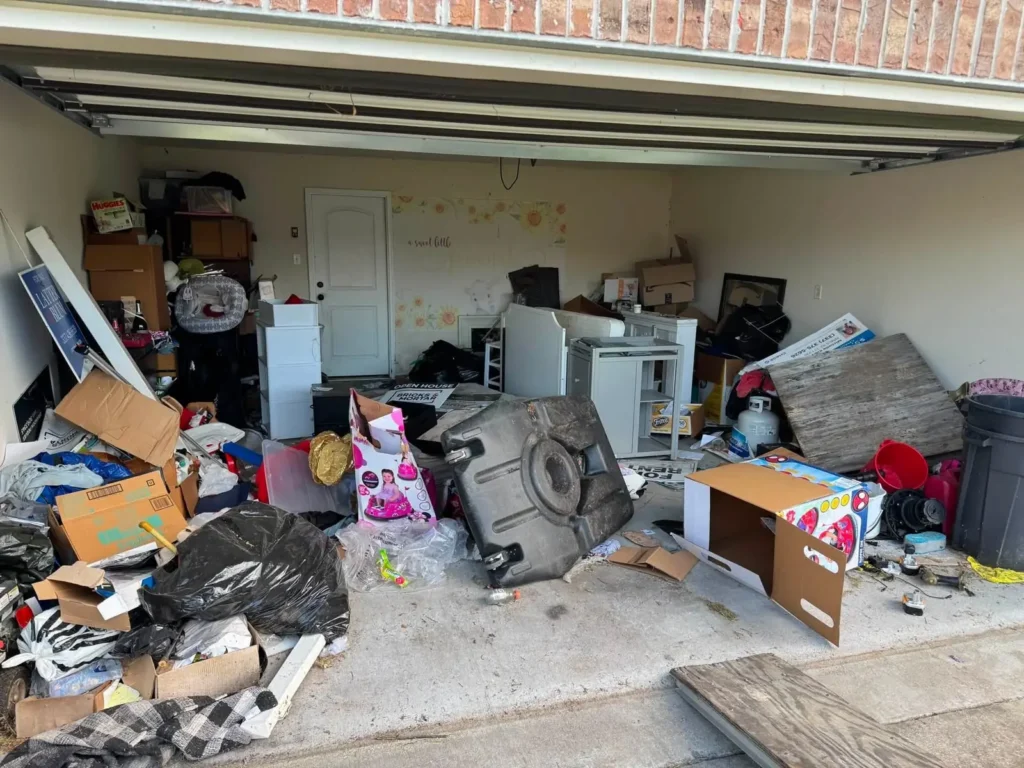 A two-car garage packed with boxes, tyres, an appliance and household clutter