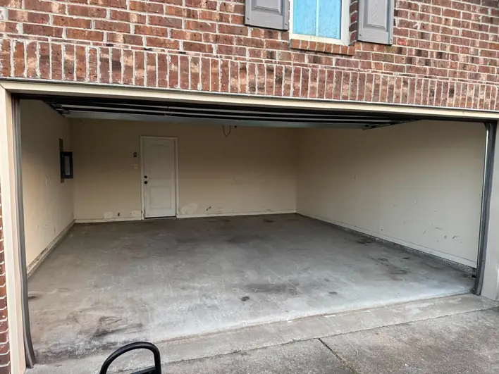 An emptied two-car garage swept down to bare concrete