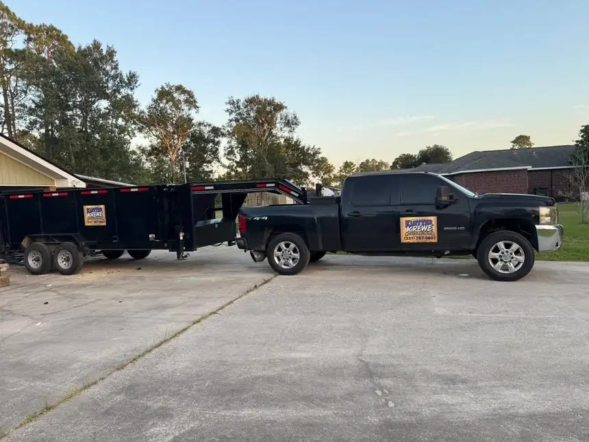 The Klutter Krewe truck and dump trailer on a driveway at dusk