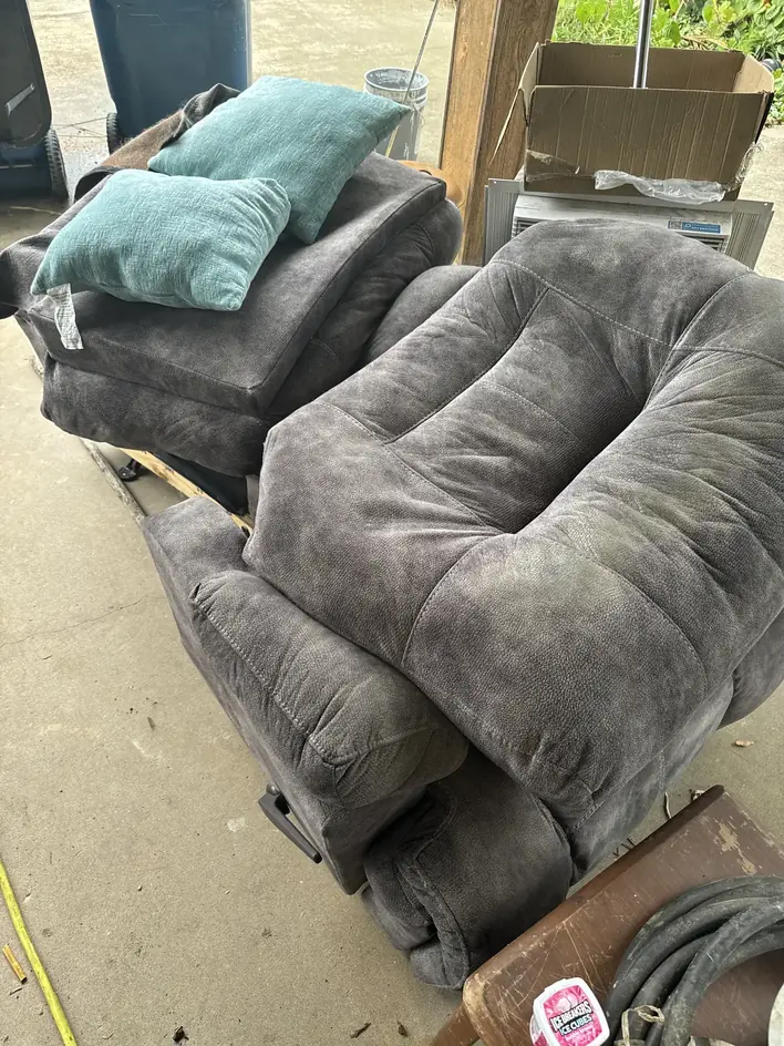 Sectional sofa and cushions stacked on a driveway ready for pickup