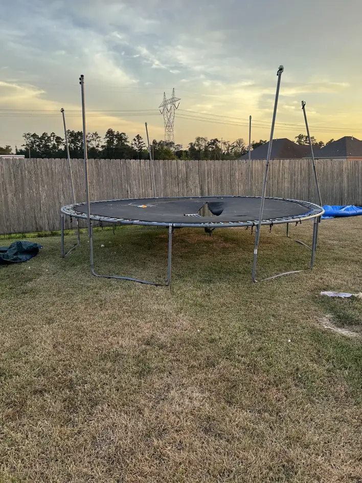 Backyard trampoline waiting to be dismantled and hauled away