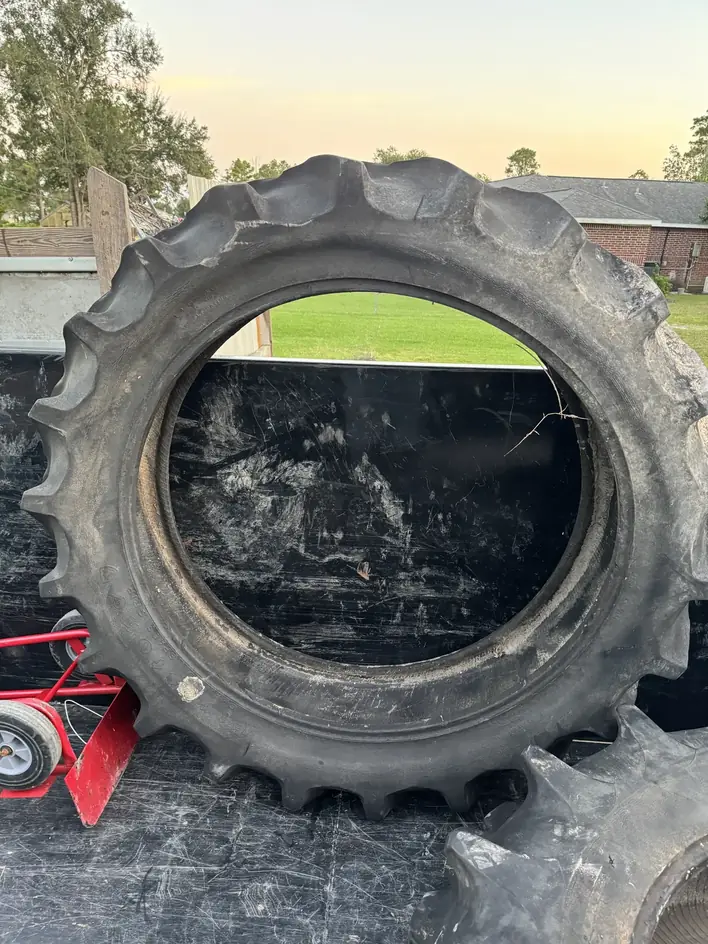 Large tractor tire being loaded into the Klutter Krewe trailer with a hand truck