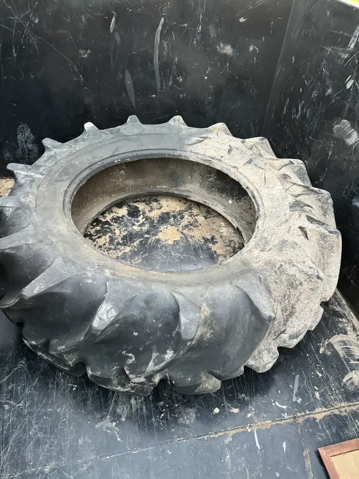 Heavy tractor tire lying in the trailer bed after loading