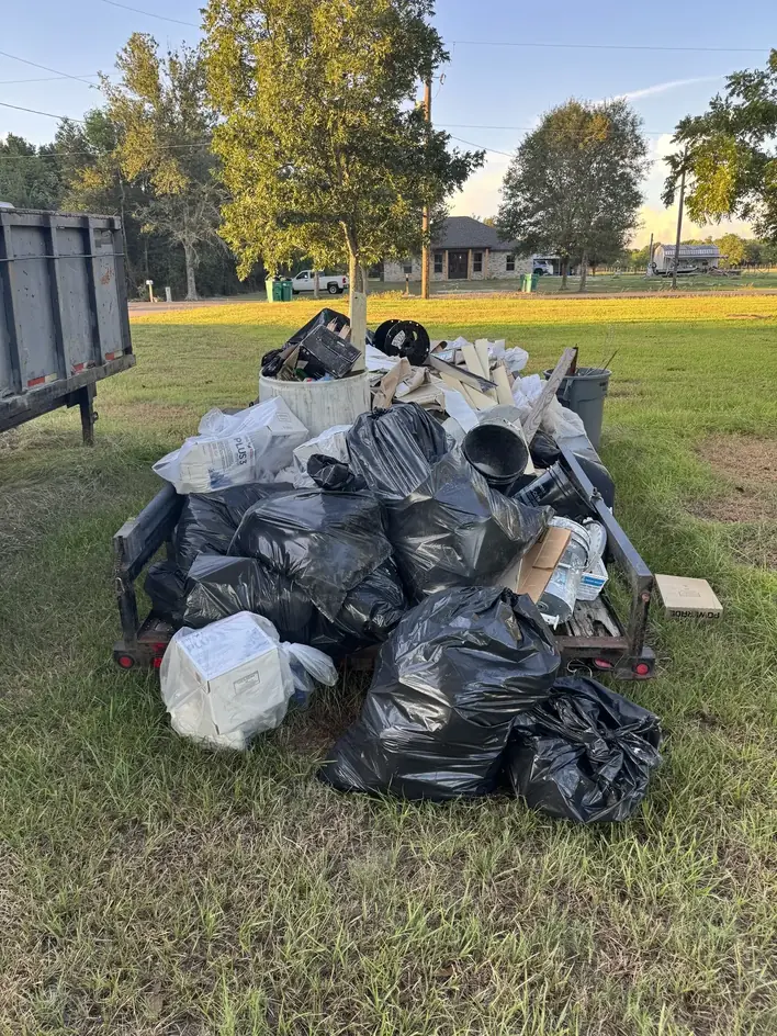Renovation debris in contractor bags and lumber loaded onto a Klutter Krewe dump trailer
