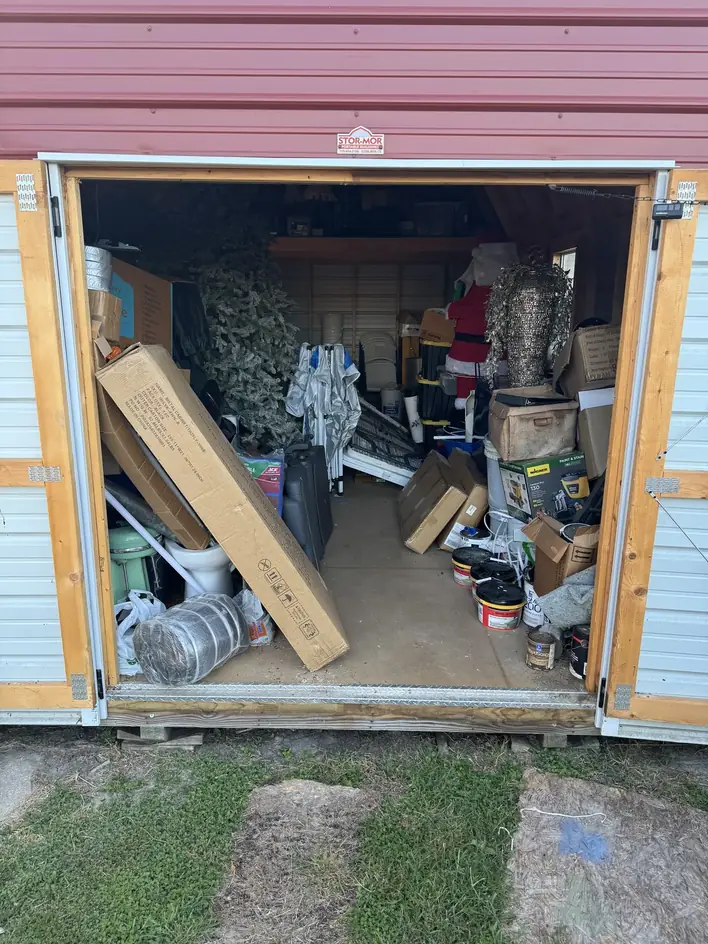 A backyard storage building packed to the doors with boxes, tools and seasonal decorations