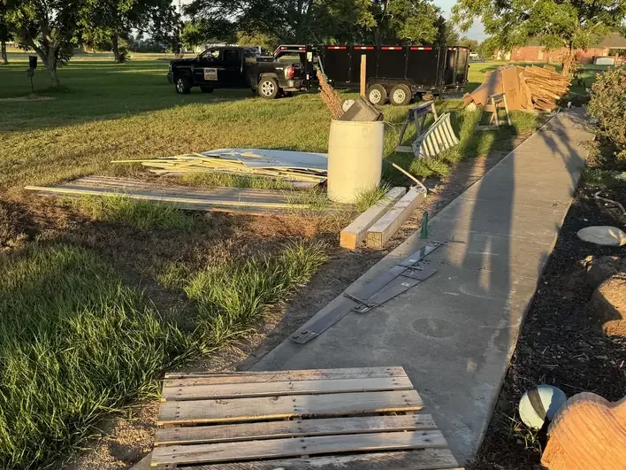 Stacked pallets on a walkway with the Klutter Krewe truck and trailer parked behind