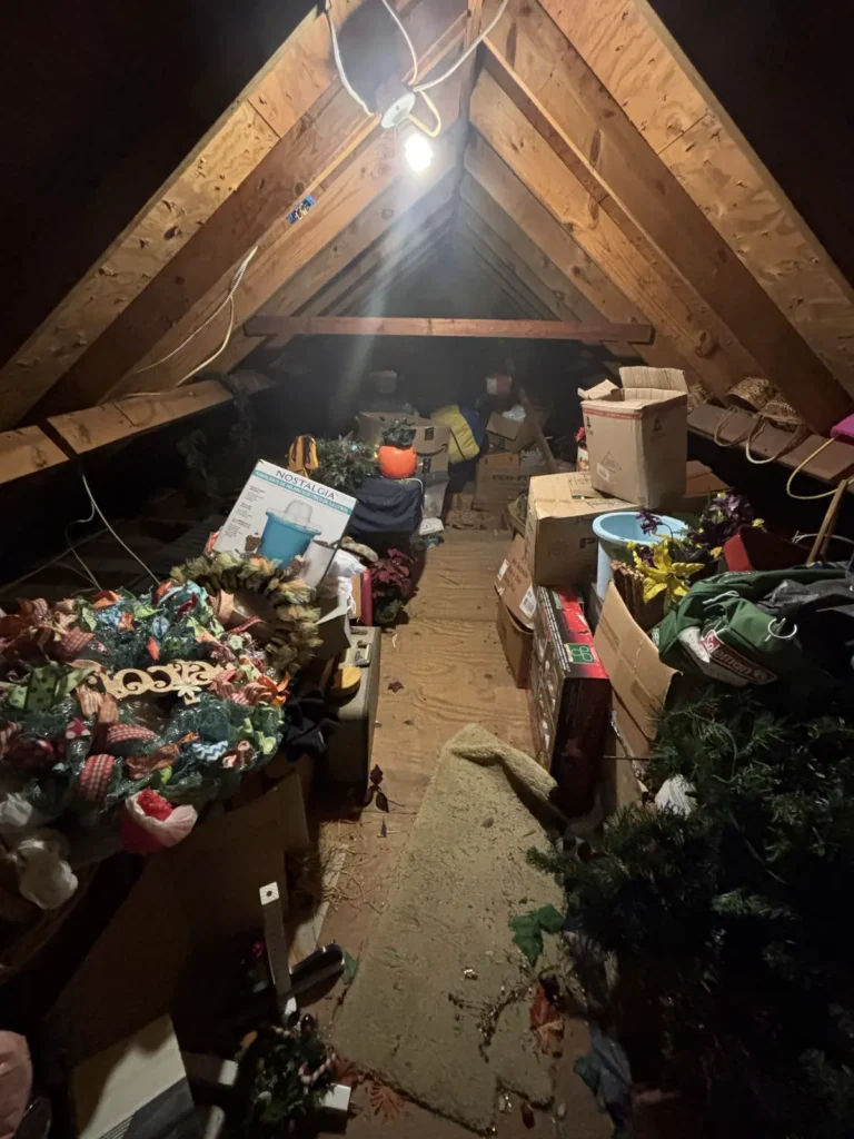 Attic packed end to end with boxes and holiday decorations before a property cleanout