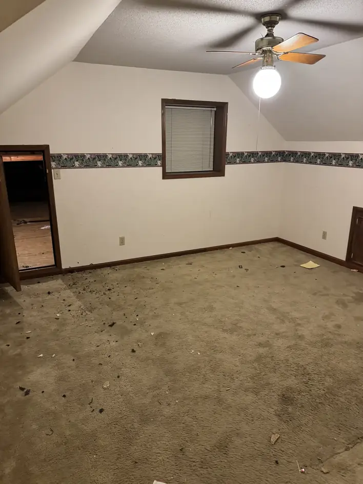 Empty carpeted bedroom left swept after a move-out cleanout