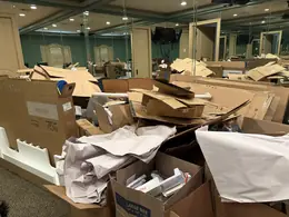 Boxes and packing debris piled through a studio before a move-out cleanout