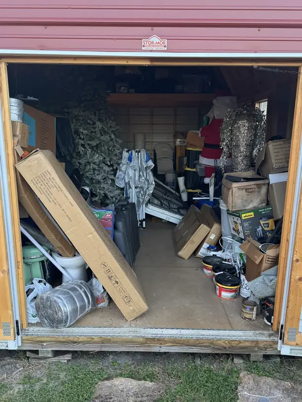 A backyard storage shed packed to the doors, waiting to be cleared out