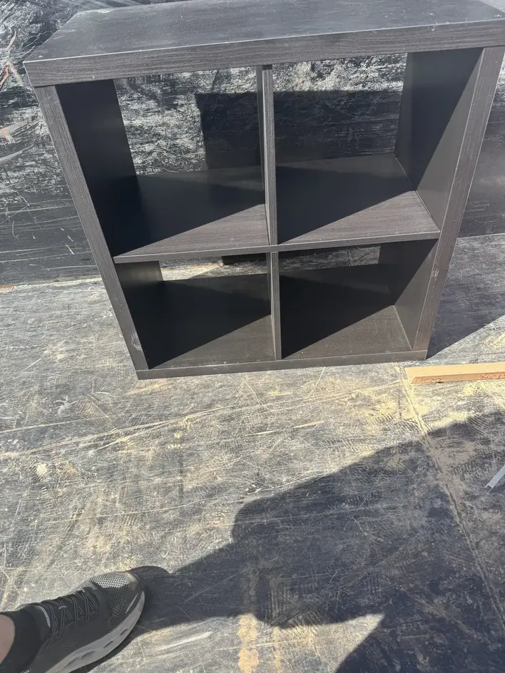 Dark cube shelving unit lying flat in the trailer bed