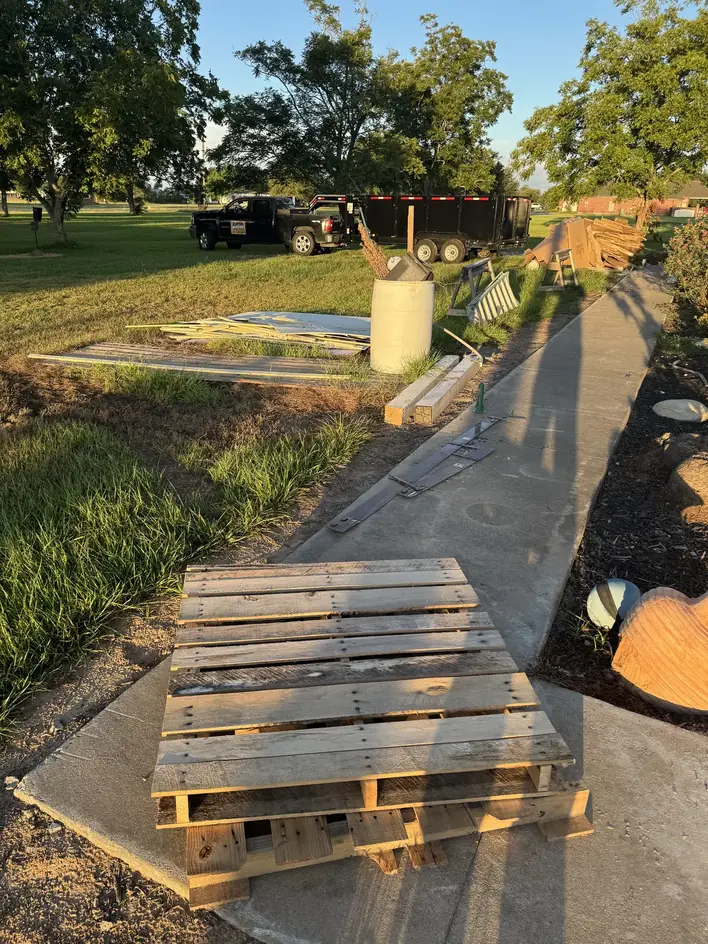 Stacked pallets on a walkway with the Klutter Krewe truck and trailer behind
