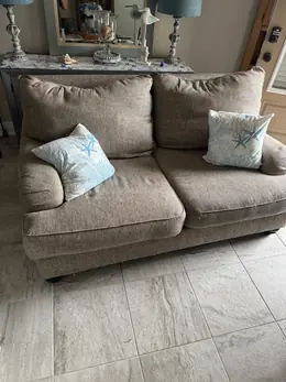 Gray sofa left in a living room, ready for single-item pickup