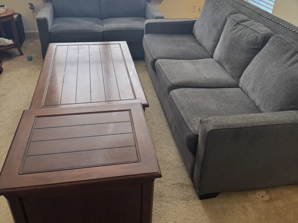 Living room of a third-floor Lake Charles apartment with two sofas and two coffee tables before a cleanout